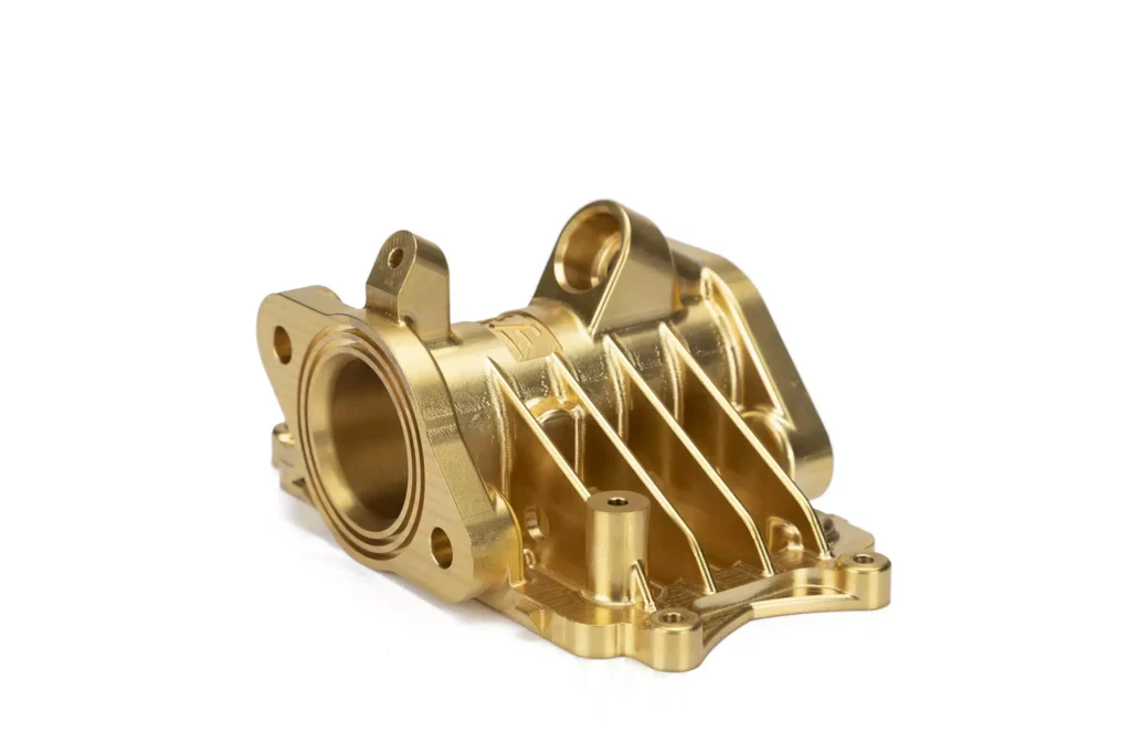 Gold CNC machined engine component.