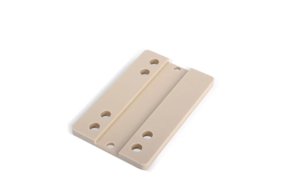 Beige plastic mounting plate with bolt holes.