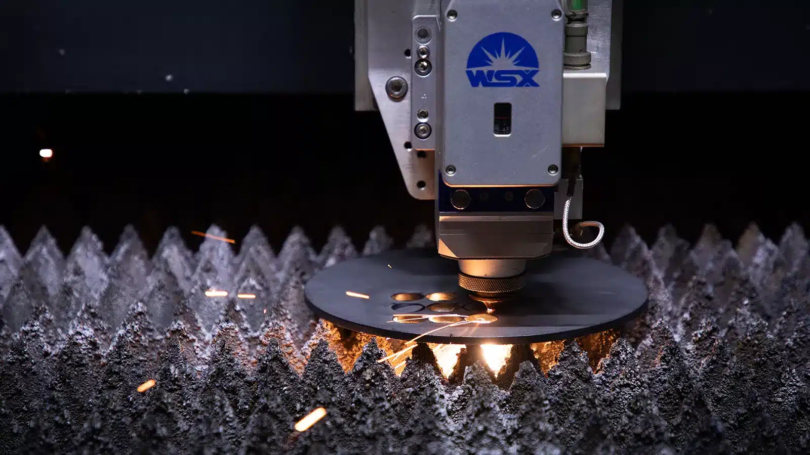 Laser cutting machine slicing through metal sheet.