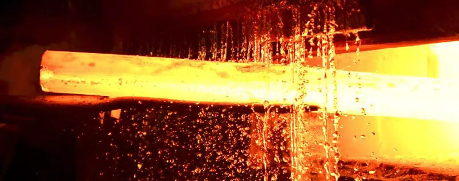 Glowing hot steel bar being cooled.
